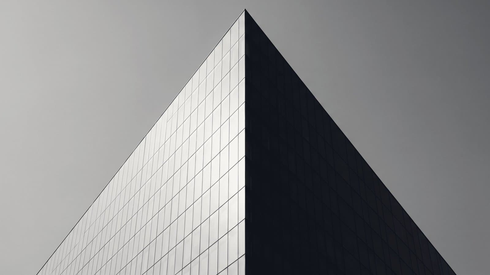 A tower corner with one face in hard light and one in deep shadow.