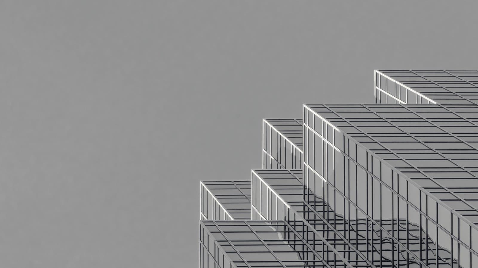 Stepped glass setbacks of a tower against a clear sky.