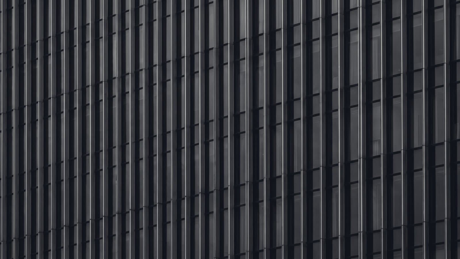 A tower facade of evenly repeated vertical mullions.