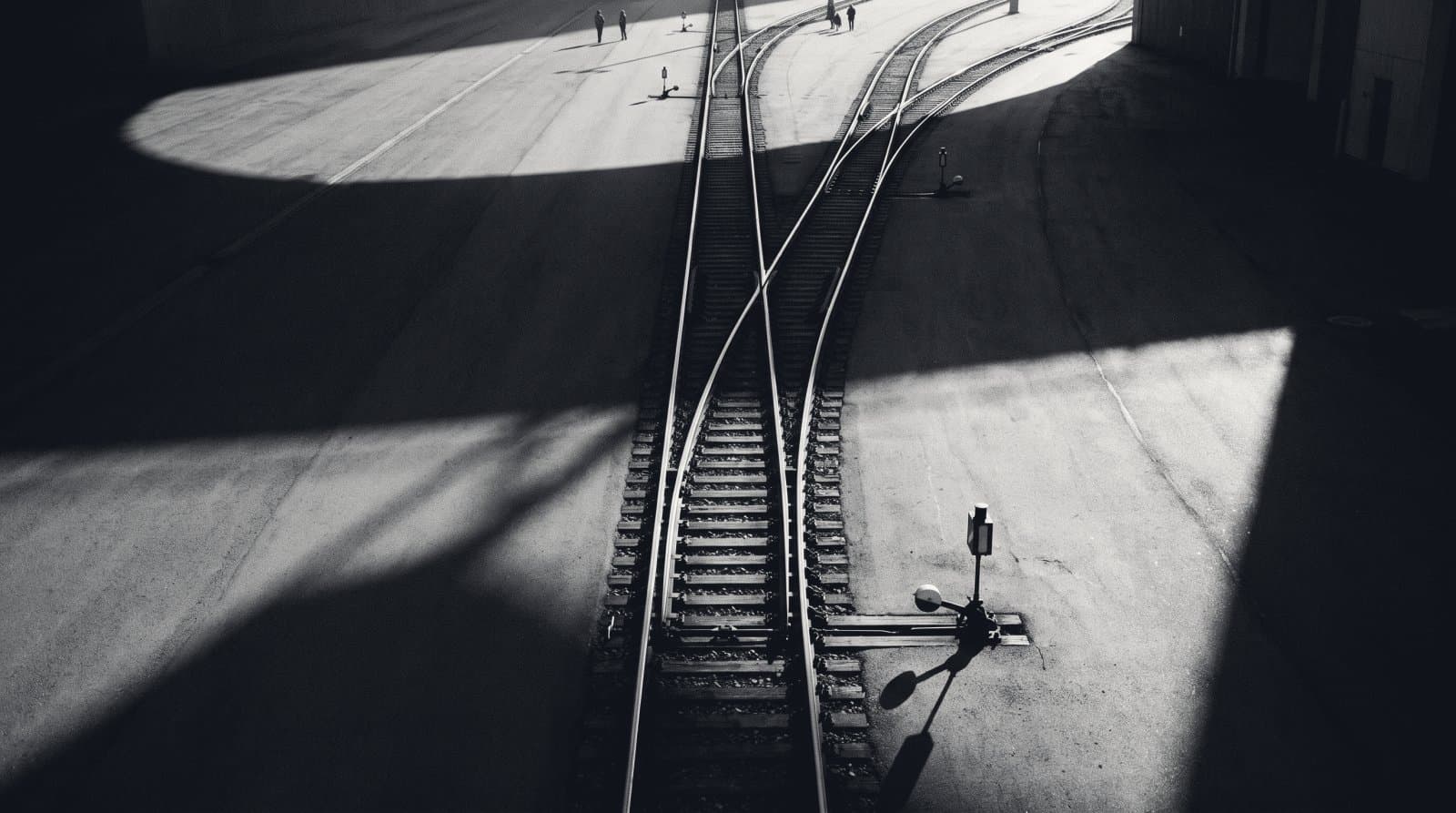 A railway switching yard photographed from above, one set of rails diverging into three at a point lever.