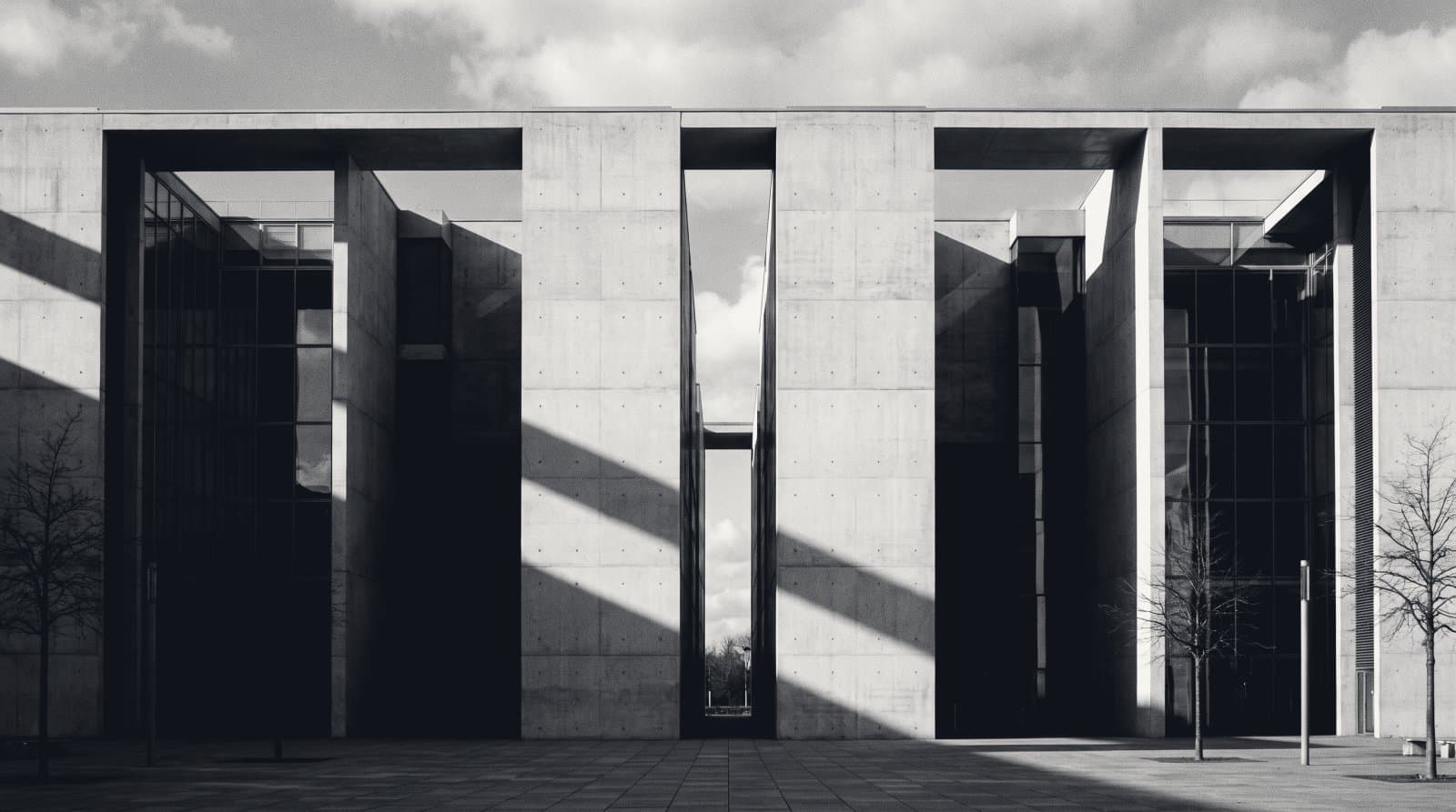 A modernist building whose wing has been separated, an open gap of sky between two halves.