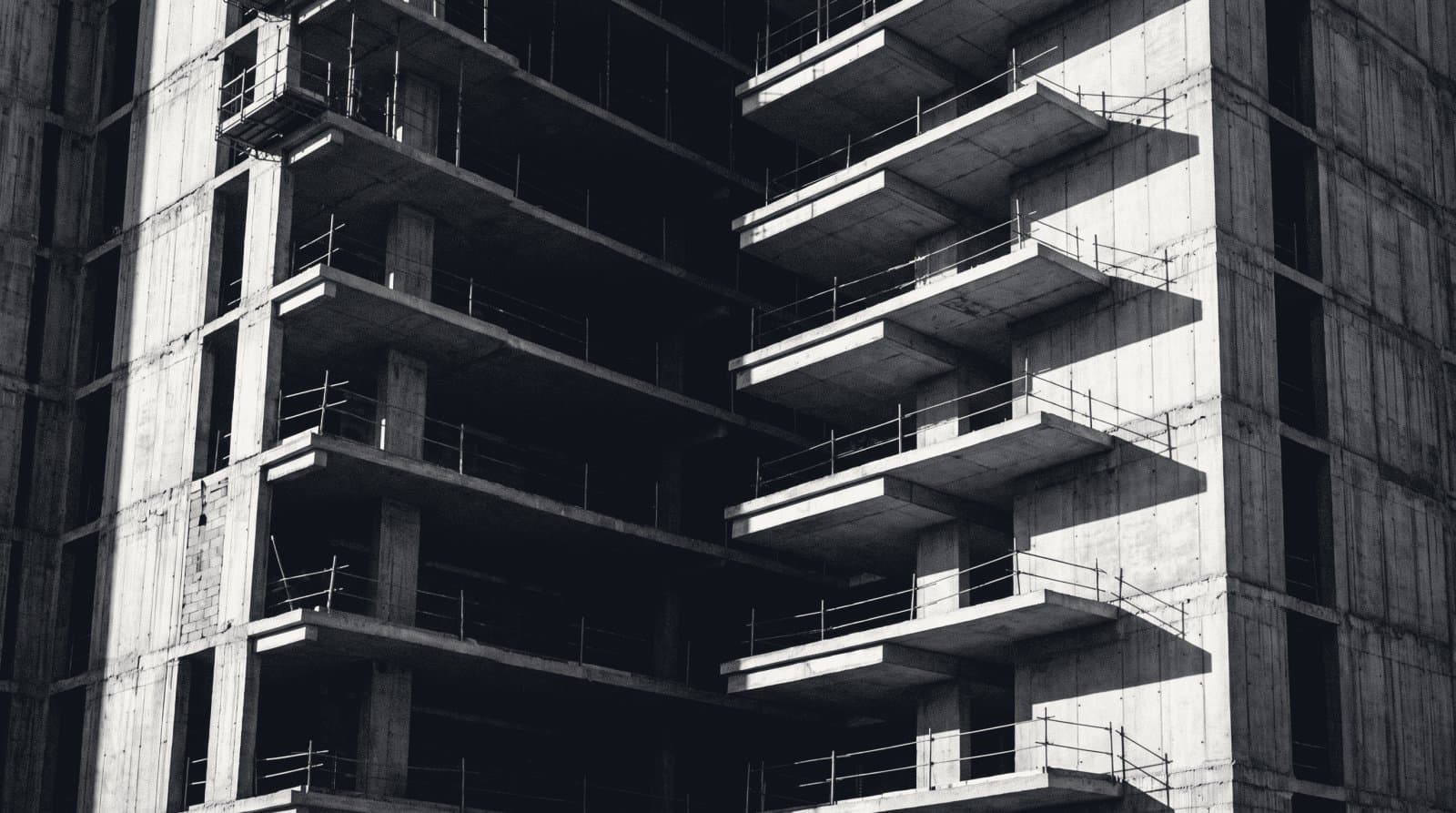 The cut edge of a concrete high-rise under construction, every floor slab stacked in section.