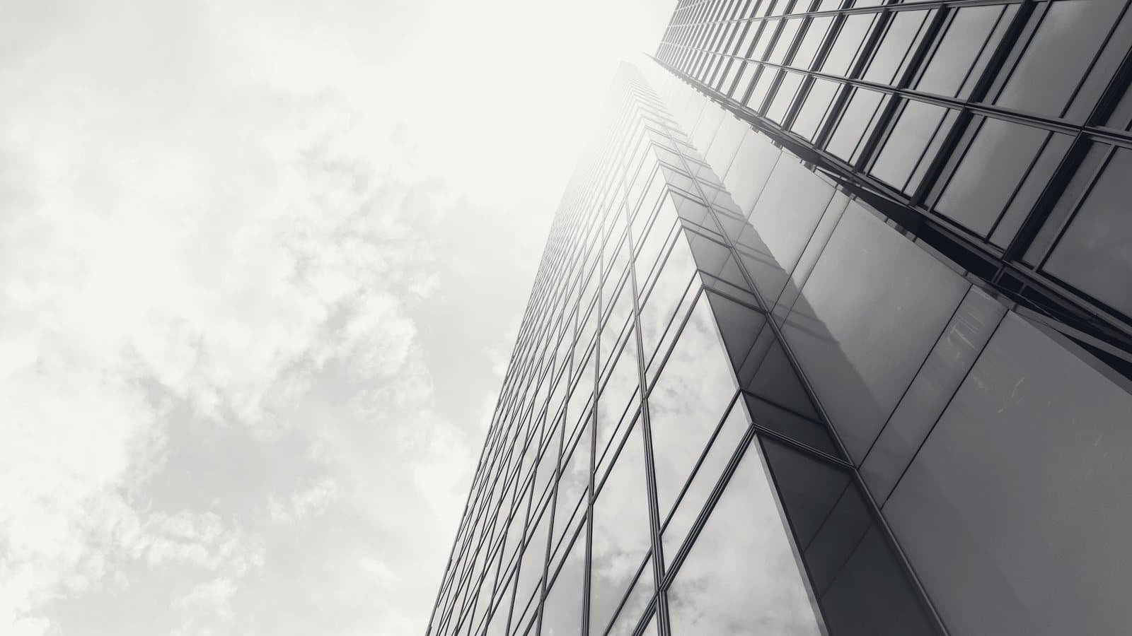 A glass tower face rising into hazy light.