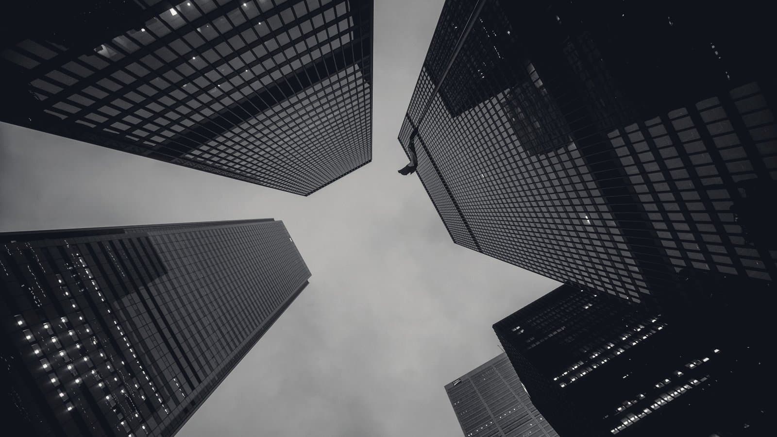 Four office towers of different heights photographed from street level, converging on a small square of open sky.
