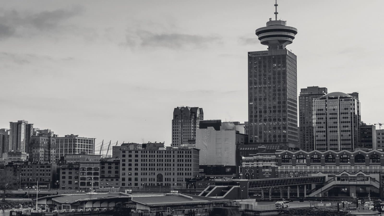 A waterfront tower over low harbor buildings.