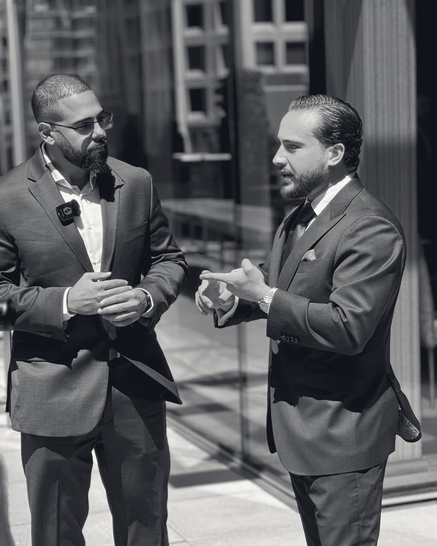Two Kadenwood principals in conversation on the plaza outside a glass office tower.